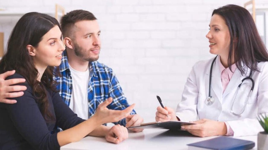 A couple sitting together with a doctor, discussing aesthetic procedures.