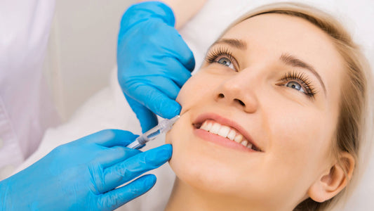 A person is given a Botox injection in their face by a professional with gloves on.