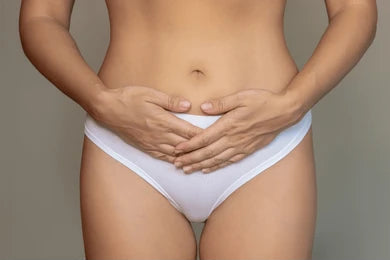 Person wearing white underwear with hands on a neutral background