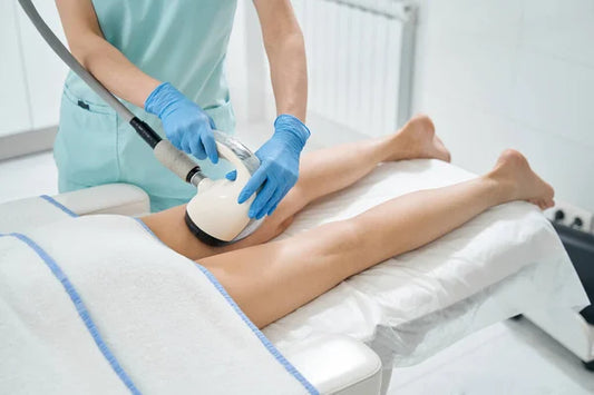 Person receiving shockwave therapy on their legs in a clinical setting 